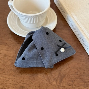 Detail of grey fabric hair claw with black polka dots, silk bow and white pearl