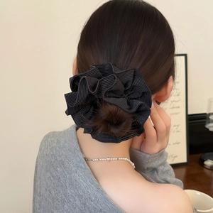 Detail of striped fabric hair scrunchie styled in a low bun for a French aesthetic look