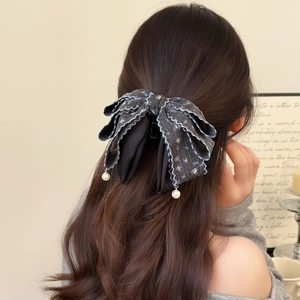 Elegant large navy denim bow hair claw clip with white lace trim and pearl drops on a model