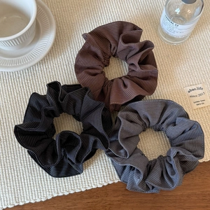 Three-piece set of striped fabric scrunchies in brown, black, and grey-blue tones