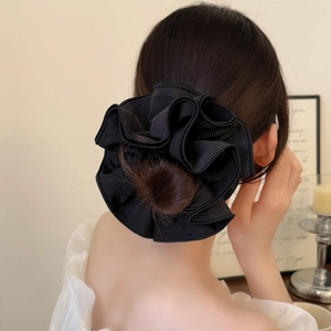 Detail of a large black striped scrunchie styling a bun hairstyle on a female model