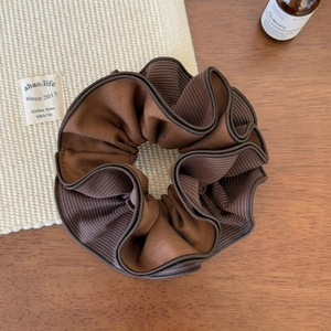 Close-up of four-layer striped hair scrunchie with coffee-colored edges and soft ruffles