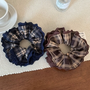 Lace plaid scrunchies in navy blue and coffee brown shown in a lifestyle set