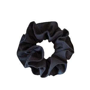 Minimalist black and white striped hair scrunchie with soft pleated fabric texture