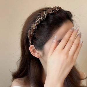 Elegant leopard print and brown satin braided headband with a gold metal button ornament