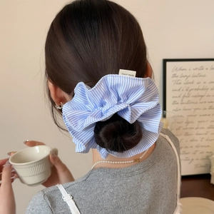 Blue and white striped fabric scrunchie with handmade tag for stylish low ponytail hairstyles