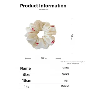 Detail of 18cm cream mesh scrunchie featuring delicate red embroidered butterfly patterns