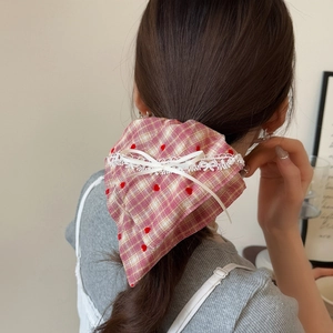 Elastico a quadretti rosa con cuori rossi, pizzo bianco e fiocco su una coda di cavallo
