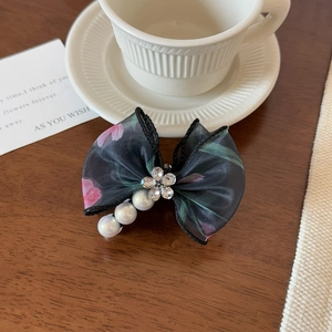 Vue détaillée d'une pince à cheveux en tulle floral avec strass et perles élégantes