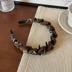 Detail of leopard print headband with inner teeth for secure hair grip on woven mat