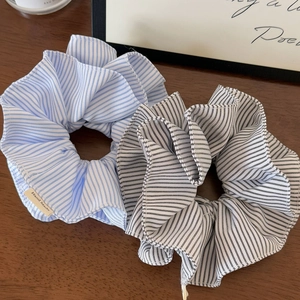 Detailed close-up of double-layered striped fabric hair scrunchies with Hand Made labels