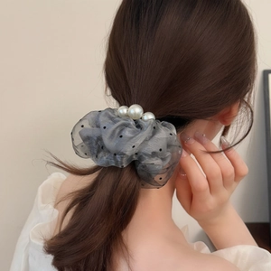 Elegant polka dot organza scrunchie with white pearl accents on messy hair bun