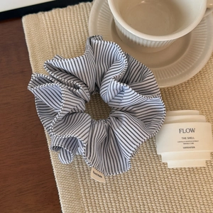 Detailed view of large black and white striped fabric scrunchie with handmade tag
