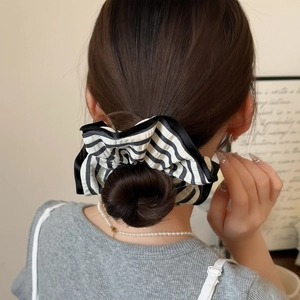 Minimalist black and white striped scrunchie for women shown on an elegant ponytail
