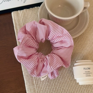 Detail showing the red and white striped fabric scrunchie with Hand Made woven label