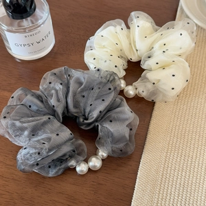 Detailed macro view of polka dot organza scrunchies featuring elegant pearl chain accents