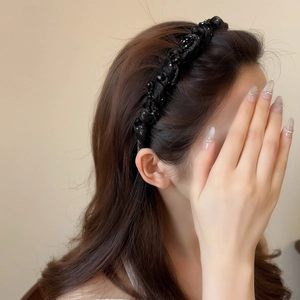Elegant black woven headband with beaded crystals on long dark brown hair