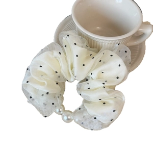 Polka dot mesh scrunchie with pearls and cream chiffon fabric shown by a coffee cup