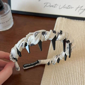 Elegant twisted white fabric headband with black camellia pattern and pearl chain accent