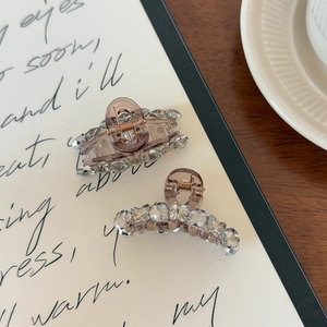 Detailed view of amber resin hair claws with crystals on a vintage aesthetic background