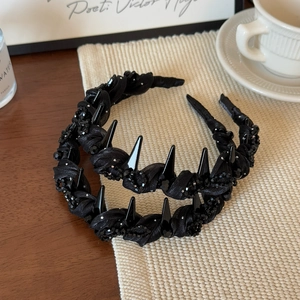 Detail of black gothic headband with hand-woven fabric, spikes and crystal beads