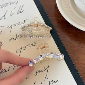Detailed macro view of a transparent hair claw clip set with iridescent AB rhinestones