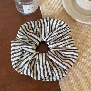 Macro shot of striped fabric scrunchie on wooden desk with elegant home decor