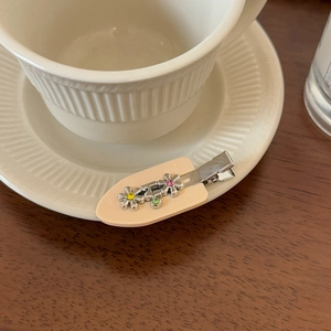 Barrette à cheveux fleurie en métal avec strass colorés sur plateau en céramique