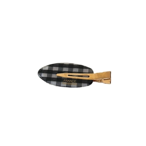 Minimalist leaf-shaped hair clip with black and white gingham pattern and gold duckbill clip