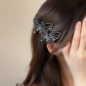 Detail of elegant double butterfly hair clip with sparkling crystals and hanging beads