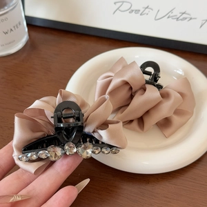Détail d'une pince à cheveux en satin avec strass en cœur et texture en tissu élégant