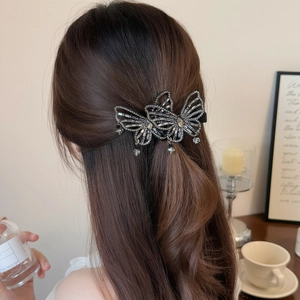 Elegant hollow butterfly hair clip with sparkling rhinestones worn on hair by a model