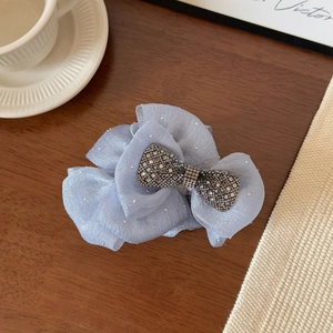 Detail of blue mesh floral hair claw clip featuring a sparkling rhinestone bow accessory