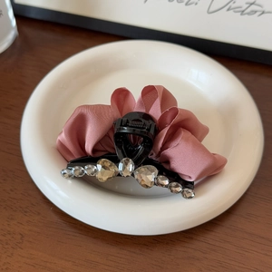 Détail d'une pince à cheveux avec ruban de satin rose et cristaux en cœur