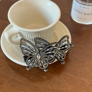 Detail of a butterfly hair clip with sparkling rhinestones and crystal drop pendant