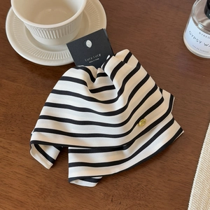 Detailed view of black and white striped hair clip with elegant gold metal accent