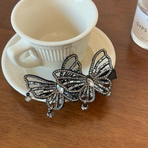 Macro shot of silver-tone hollow butterfly hair clip with sparkling rhinestones and crystal charms