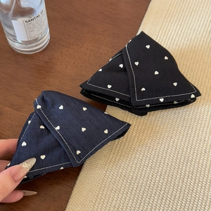 Detailed view of denim triangle hair clips with heart prints and fine white stitching