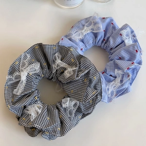 Détail de chouchous à carreaux avec bordure en dentelle blanche et broderie délicate