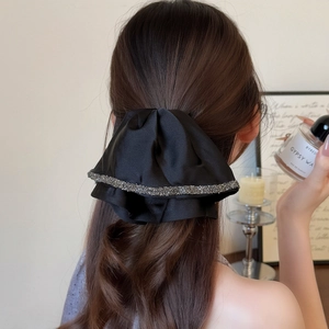 Elegant black satin bow hair claw clip with rhinestones for a sophisticated ponytail look