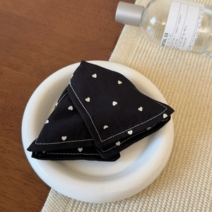 Close-up of denim heart print fabric texture with detailed white stitching on hair clip