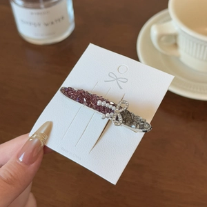 Elegant silver hair clip with purple crystals and pearl bow on a white display card