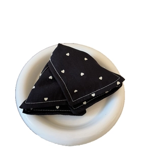 Denim heart print triangle hair clip with white stitching on minimalist white plate