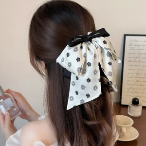 Elegant white satin camellia bow hair clip with black CHANGE ribbon for women