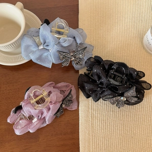 Détail de pinces à cheveux en tulle avec nœuds et strass en bleu, violet et noir élégant