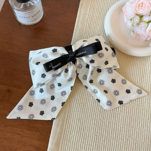 Elegant camellia bow hair claw clip with CHANGE ribbon on a minimalist aesthetic background