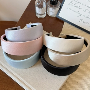 Selection of colorful satin padded headbands arranged on books for a stylish look