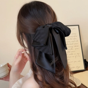 Détail d'une pince à cheveux avec nœud en satin noir élégant dans un style vintage