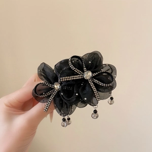 Detail of black mesh bow hair claw clip with rhinestones and hanging crystal tassels