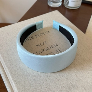 Detail of light blue padded headband with fine fabric texture and non-slip lining